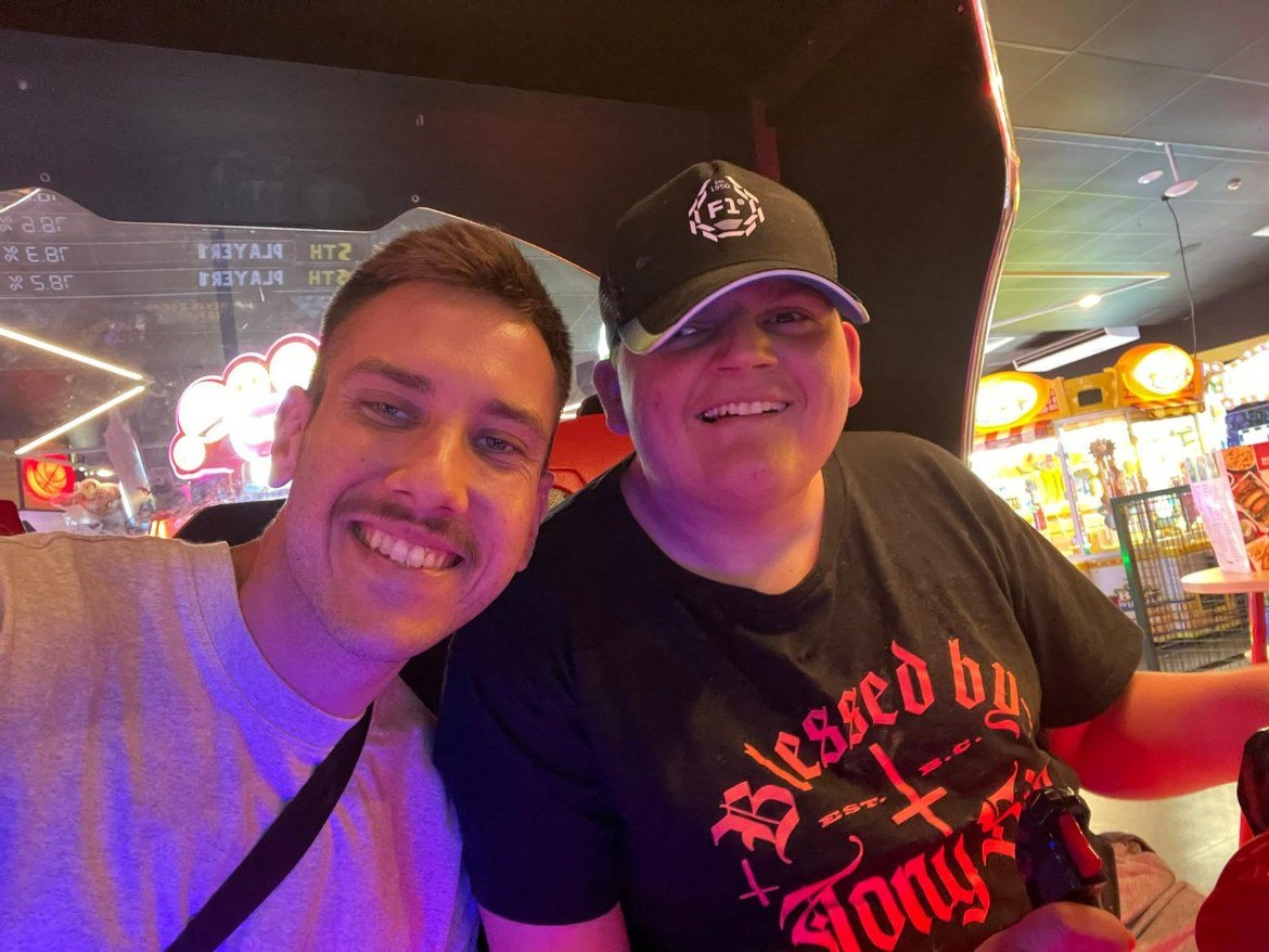 Support worker and participant having fun together at an arcade
