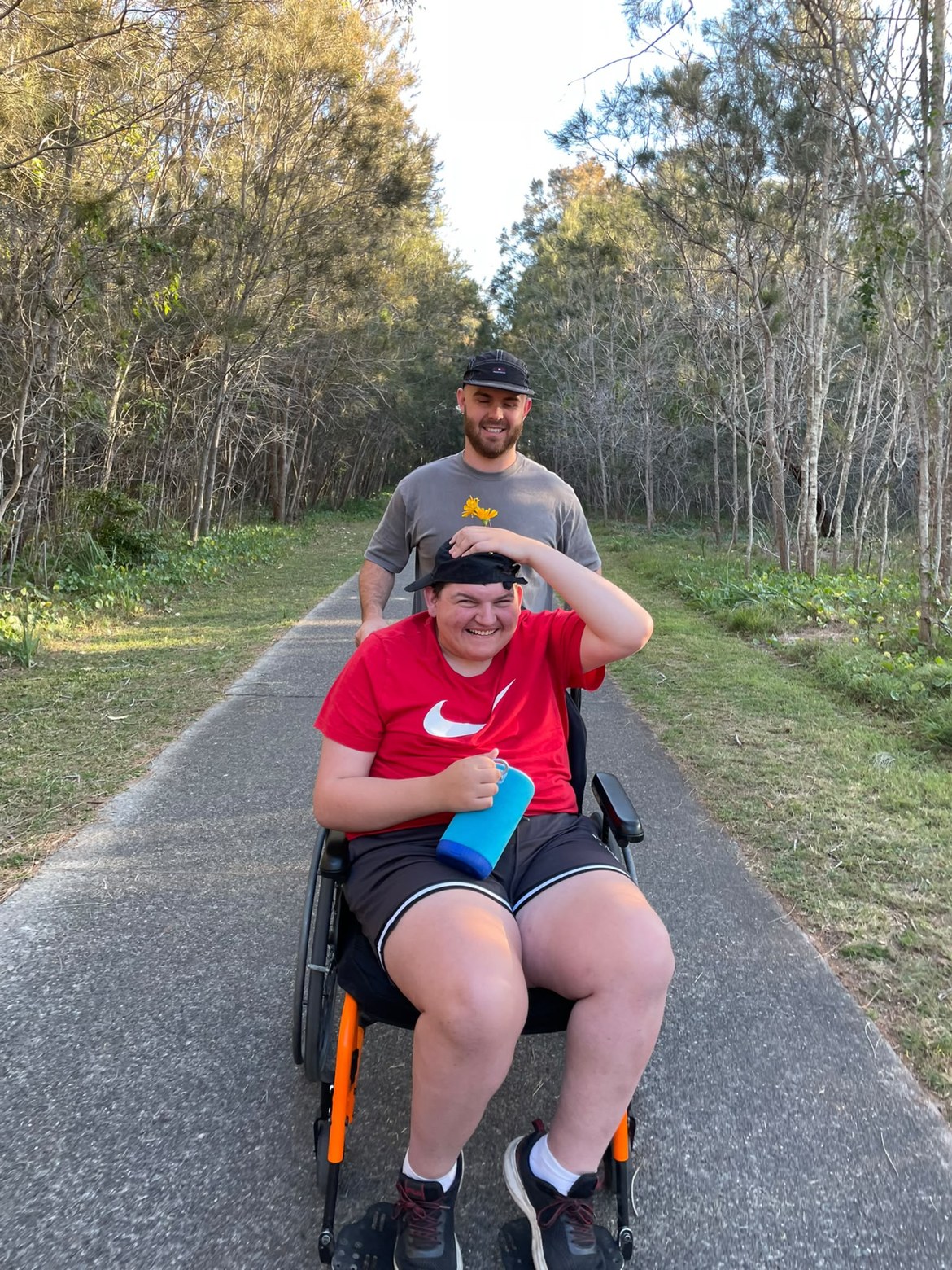 Support worker and participant on a forest walking trail