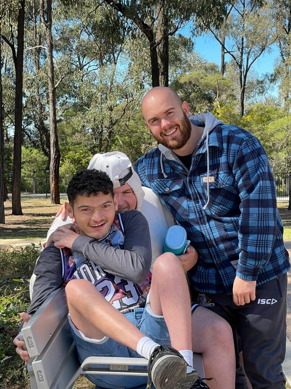 Support worker and participants relaxing on a park bench