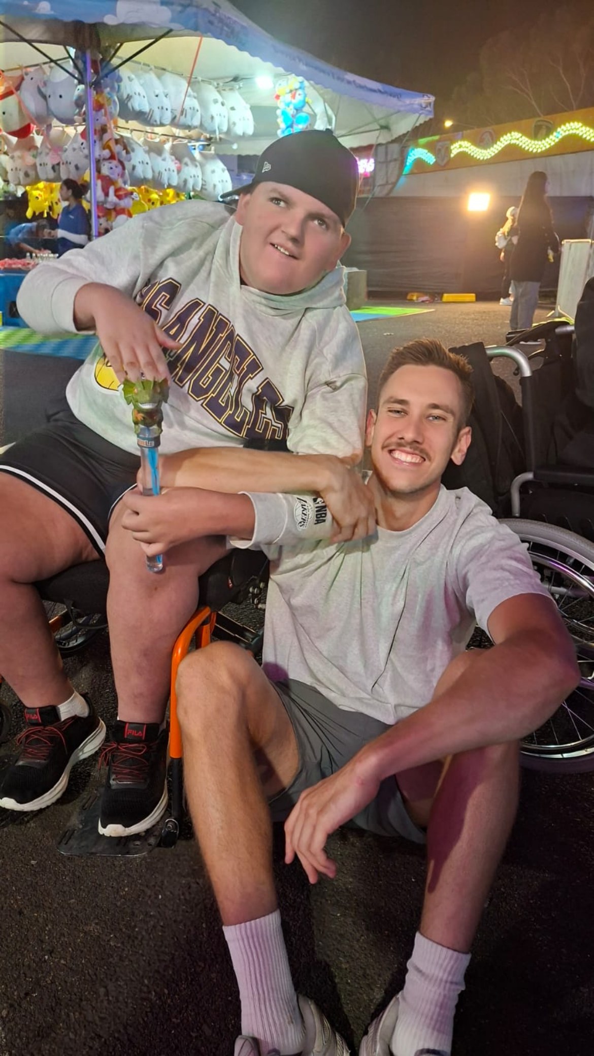 Support worker and participant enjoying a showground at night