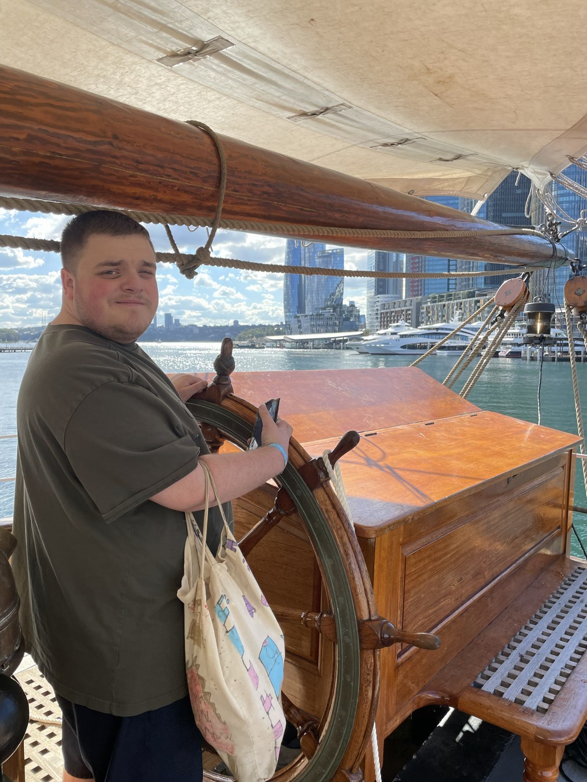 Participant steering a tall ship on Sydney Harbour